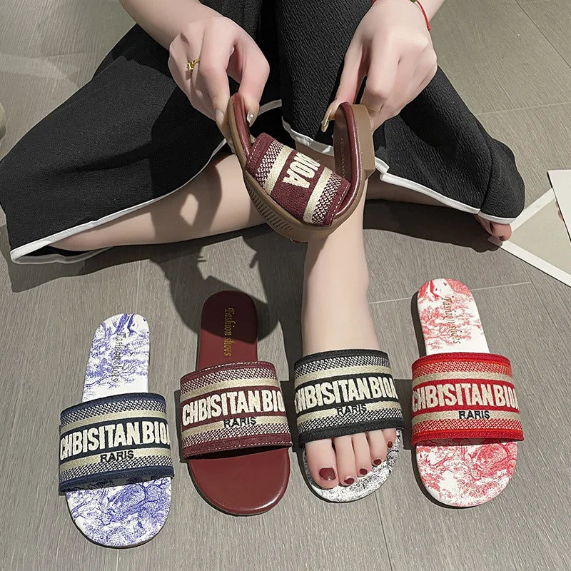 Slippers for women wearing on the outside, new round toe flat bottomed embroidered letter one line beach sandals for summer 2023